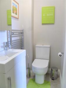 La salle de bains est pourvue de toilettes blanches et d'un lavabo. dans l'établissement Chalice Lodge, à Glastonbury