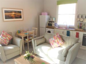 uma sala de estar com dois sofás e uma cozinha em Chalice Lodge em Glastonbury