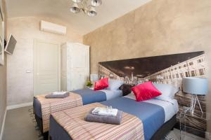 a bedroom with two beds and a painting on the wall at Cerea BnB in Turin