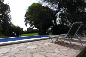 2 sillas sentadas junto a una piscina en Finca La Falda en Cerrillos