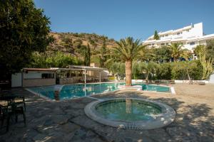 een zwembad in een resort met bomen en een gebouw bij Neos Ikaros in Agia Galini