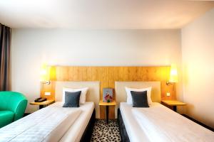 Postel nebo postele na pokoji v ubytování Offenbach Plaza Hotel + 28 fotografií