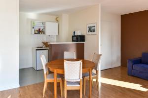 - une salle à manger et une cuisine avec une table et des chaises dans l'établissement Welkeys Apartment - Allee de Liege, à Lille