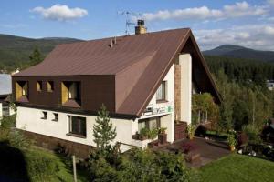a large house with a brown roof at Pension Simona in Harrachov