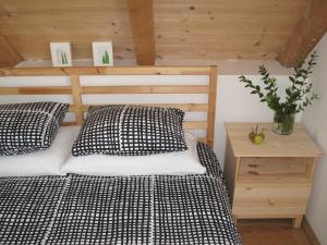 a bedroom with a bed and a night stand with a plant at Guesthouse Bor Plitvice Lakes in Plitvička Jezera