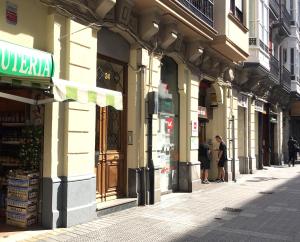 a street with people standing outside of a building at Bilbao Central Rooms in Bilbao