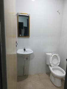 a bathroom with a toilet and a sink and a mirror at Axis Hotel in Taiping