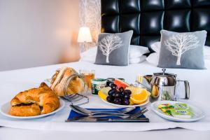 a breakfast tray with croissants and fruit on a bed at The Royal Hotel Cardiff in Cardiff