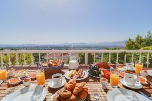 een ontbijttafel met eten en drinken op een balkon bij Villa Politia in Athene