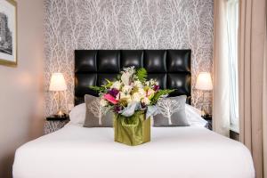 a vase of flowers sitting on top of a bed at The Royal Hotel Cardiff in Cardiff
