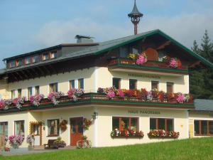 a large white building with flowers on the balconies at Panorama Appartement in Ramsau am Dachstein