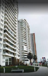 un gran edificio de apartamentos con un parque infantil delante de él en Departamento Costa Mansa, en Coquimbo