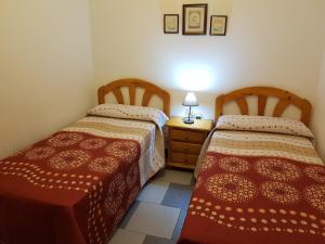 2 Betten nebeneinander in einem Zimmer in der Unterkunft Benamahoma Rural in Benamahoma