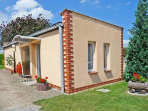 a small brick house with flowers in the yard at Bungalow im Garten in Malchow