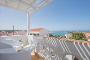 a balcony with white chairs and a view of the ocean at Guarda Rios in Vila Nova de Milfontes
