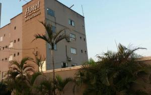 a hotel building with palm trees in front of it at Imbau Palace Hotel in Imbau +5 photos