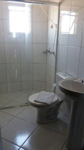 Baño blanco con aseo y lavamanos en Imbau Palace Hotel, en Imbau