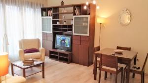 sala de estar con TV, escritorio y silla en Apartamento Arica, en Granada