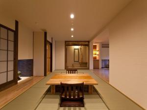 a dining room with a wooden table and chairs at Gokuraku Onsen Takumi no Yado in Takaharu