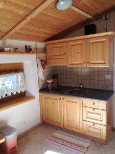 a kitchen with wooden cabinets and a sink at B&B El Molin in Cavalese