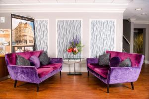 a living room with two purple chairs and a table at The Royal Hotel Cardiff in Cardiff