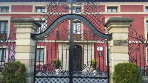 un gran edificio rojo con una puerta negra en Posada Santa Eulalia en Villanueva de la Peña