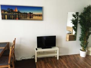 uma sala de estar com televisão numa mesa branca em Apartment Treetown em Regensburg