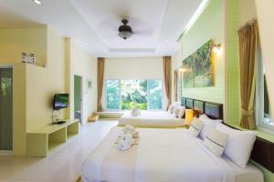two beds in a room with a large window at Watermill Resort in Nong Nam Daeng