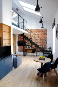a living room with a table and a brick wall at Aparthotel BC 29 Residence in Kraków