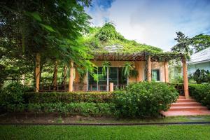 dom pokryty bluszczem z gankiem i schodami w obiekcie Watermill Resort w mieście Nong Nam Daeng
