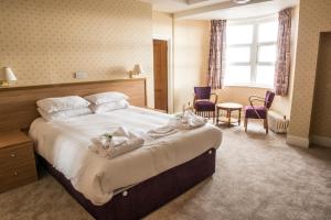 a hotel room with a bed with towels on it at Seabank Hotel in Porthcawl