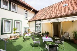 a patio with tables and chairs in a building at Hotel Deutsches Haus in Northeim