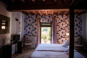 a bedroom with a bed with blue and white wallpaper at De Aldaca Rural - Only Adults in Jerte