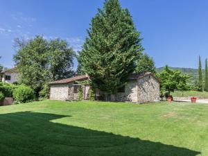 a stone house with a tree in a yard at Belvilla by OYO San Martino in Ambra