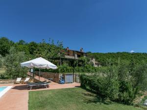 een huis met een parasol en een zwembad bij Belvilla by OYO Zafferano in Morrano