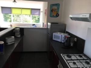 a kitchen with a stove and a counter with a microwave at location appartement in Wissant