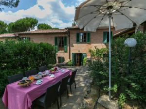 a table with a pink table cloth and an umbrella at Villa in Siena with Pool and Tuscan Views in Siena
