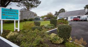 a sign in a yard with bushes and a house at Greenacre in Oban
