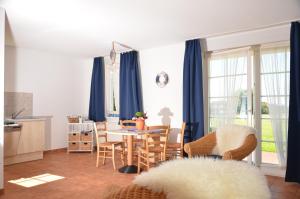 a kitchen and dining room with blue curtains and a table at Ferienwohnung Landtraum in Neddesitz