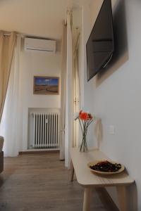 a living room with a table and a tv on a wall at Piccolo Borgo Antico in Florence