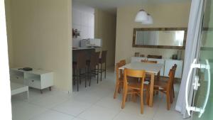 马拉戈日Condomínio Village, Casa Cecília的配有桌椅的厨房和餐厅