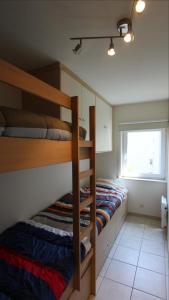 - une chambre avec 2 lits superposés et une fenêtre dans l'établissement Residentie Gaudi, à Nieuport