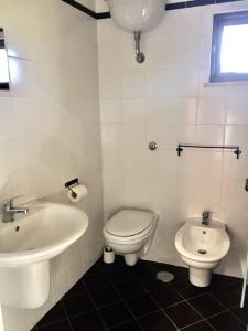 a white bathroom with a sink and a toilet at Sentieri Luminosi in SantʼAgata deʼ Goti