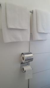 ein Badezimmer mit weißen Handtüchern und einer Rolle Toilettenpapier in der Unterkunft Hotel Alt Steinbach in Steinbach im Taunus