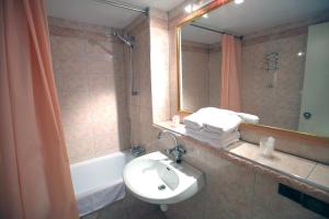a bathroom with a sink and a mirror and a tub at Hôtel Restaurant Au Relais D'Alsace in Rouffach