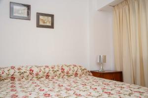 sypialnia z łóżkiem z narzutą kwiatową w obiekcie 3 o 4 PERSONAS A 150 Mts SANATORIO ALLENDE w Córdobie