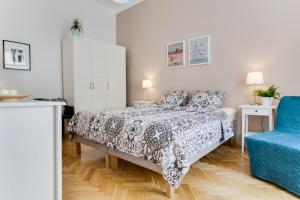 プラハにあるJT's Apartments Jecna str.のベッドルーム1室(ベッド1台、青い椅子付)