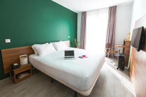 a hotel room with a bed with a laptop on it at The Social Hub Paris La Défense in Puteaux