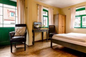 a bedroom with a bed and a desk and a chair at Pension Rauschenstein in Bad Schandau