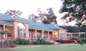 a large brick house with a lawn in front of it at Pericoe Retreat in Dubbo